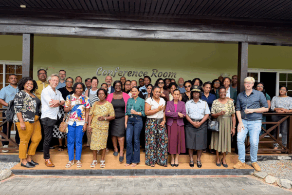 Groep Surinaamse mannen en vrouwen in Suriname, samen met medewerkers van Reclassering Nederland