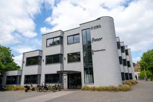wit gebouw met een ronde hoek, met zwarte glasreflecterende ramen