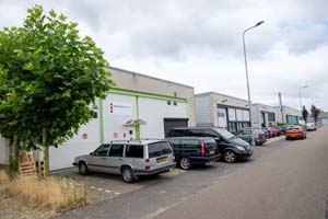 Werkstraflocatie Rosmalen van Reclassering Nederland, een wit gebouw met ervoor een parkeerplaats met auto's.