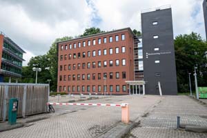 Roodbruin complex met vijf verdiepingen, achter een slagboom