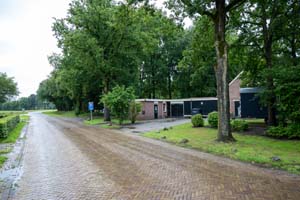 looppad omringd door bos, naast een bruin complex